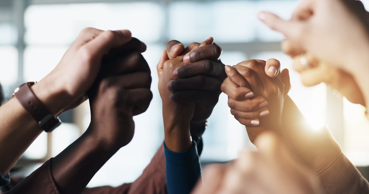 Grupo de personas tomadas de las manos en oración y unidad